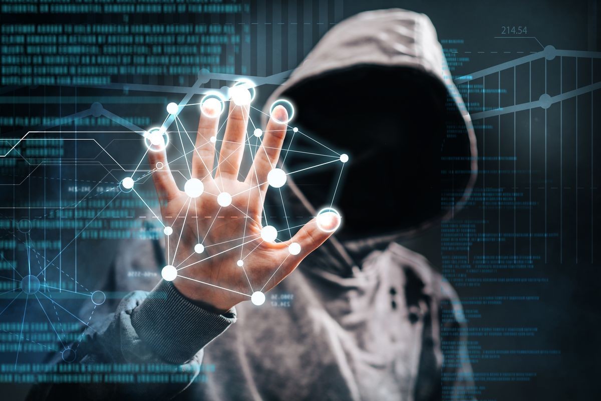 Hacker in hoodie touching digital network with glowing nodes and data streams.