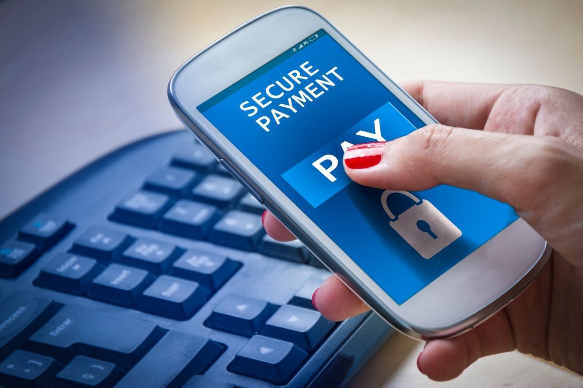 Person using smartphone for secure payment with a blue screen showing 'PAY' button and lock symbol.